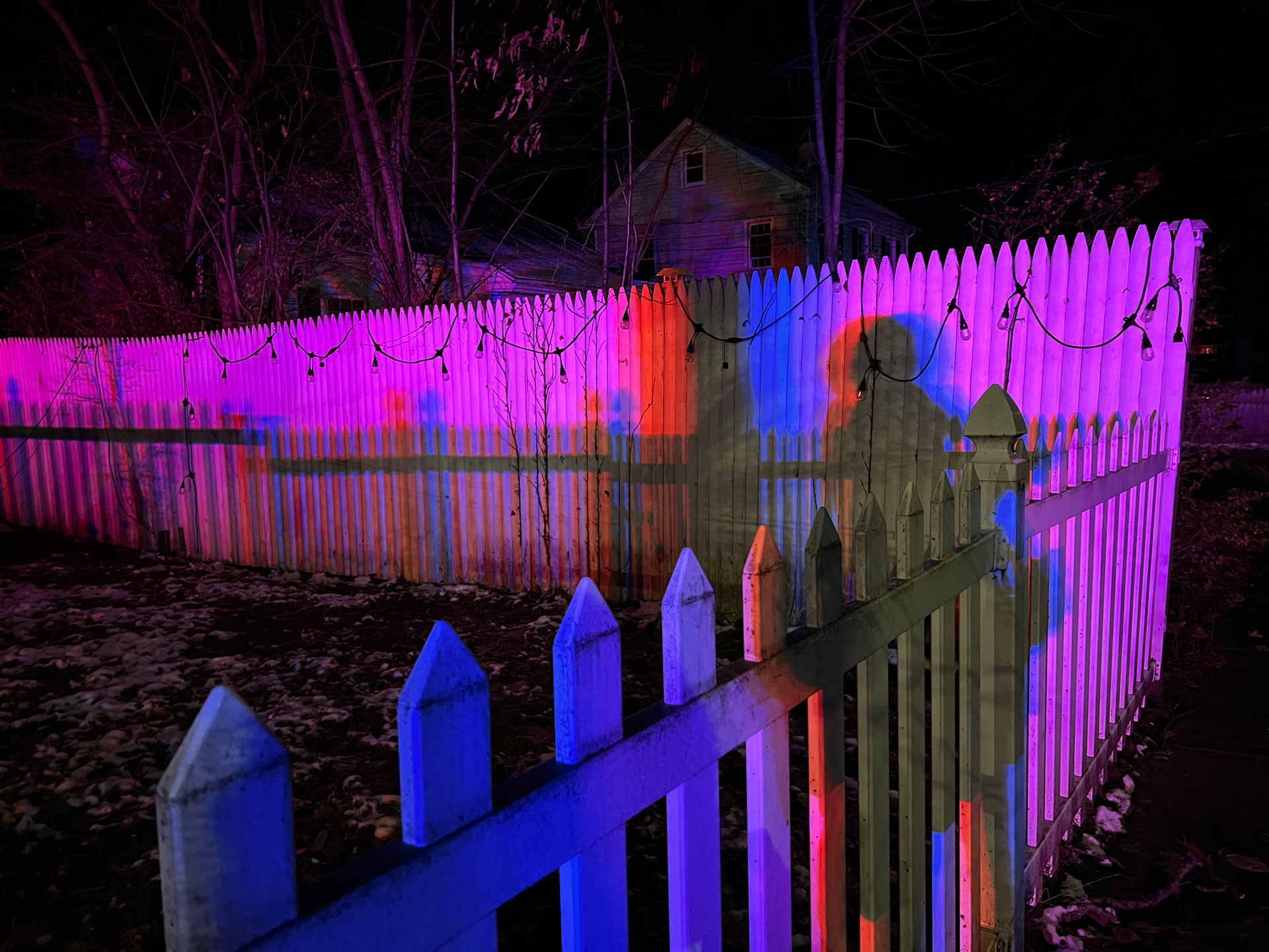 Nighttime scene of fence with colored lights