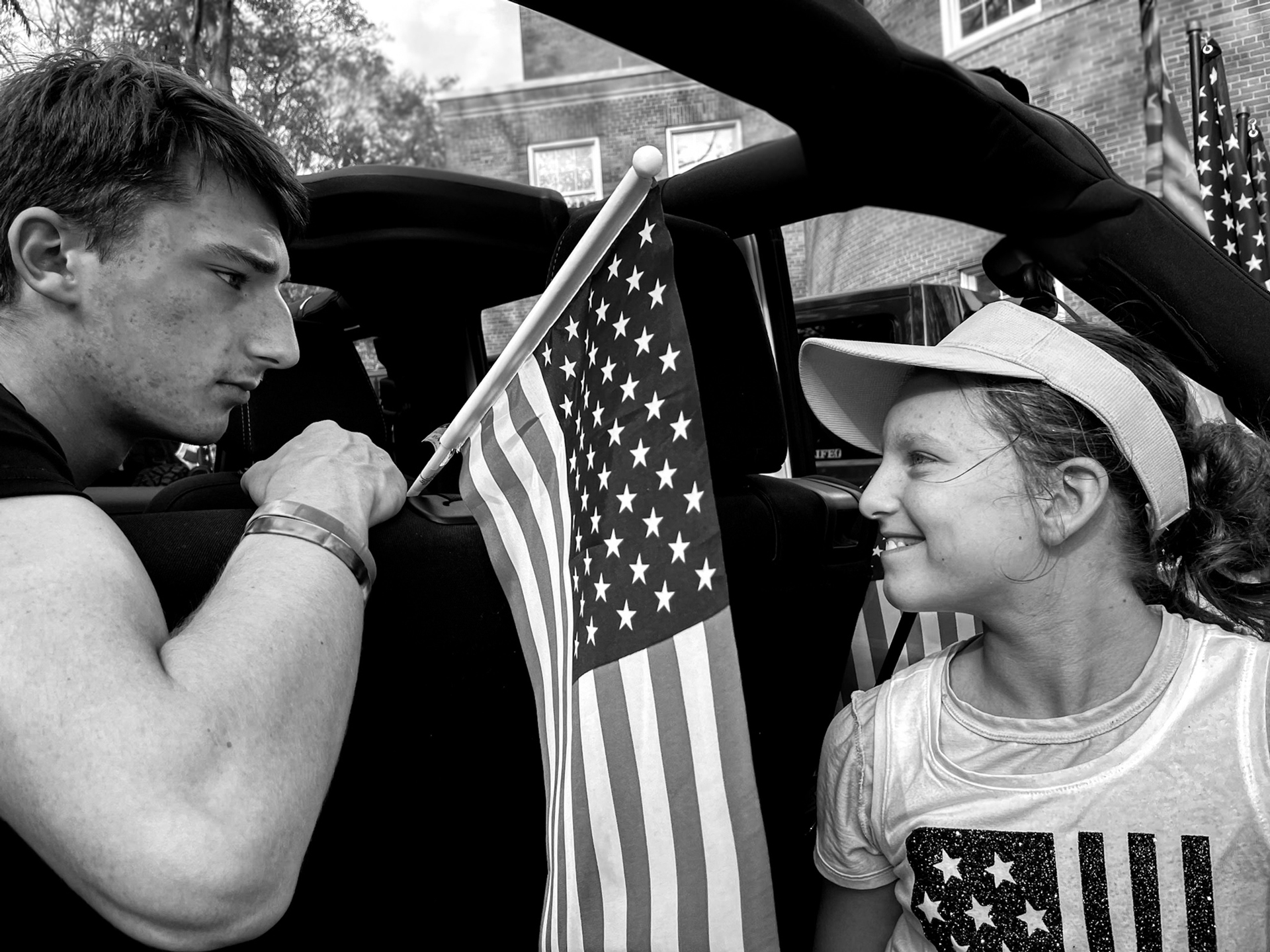Black and white photograph of two people with an American flag between them
