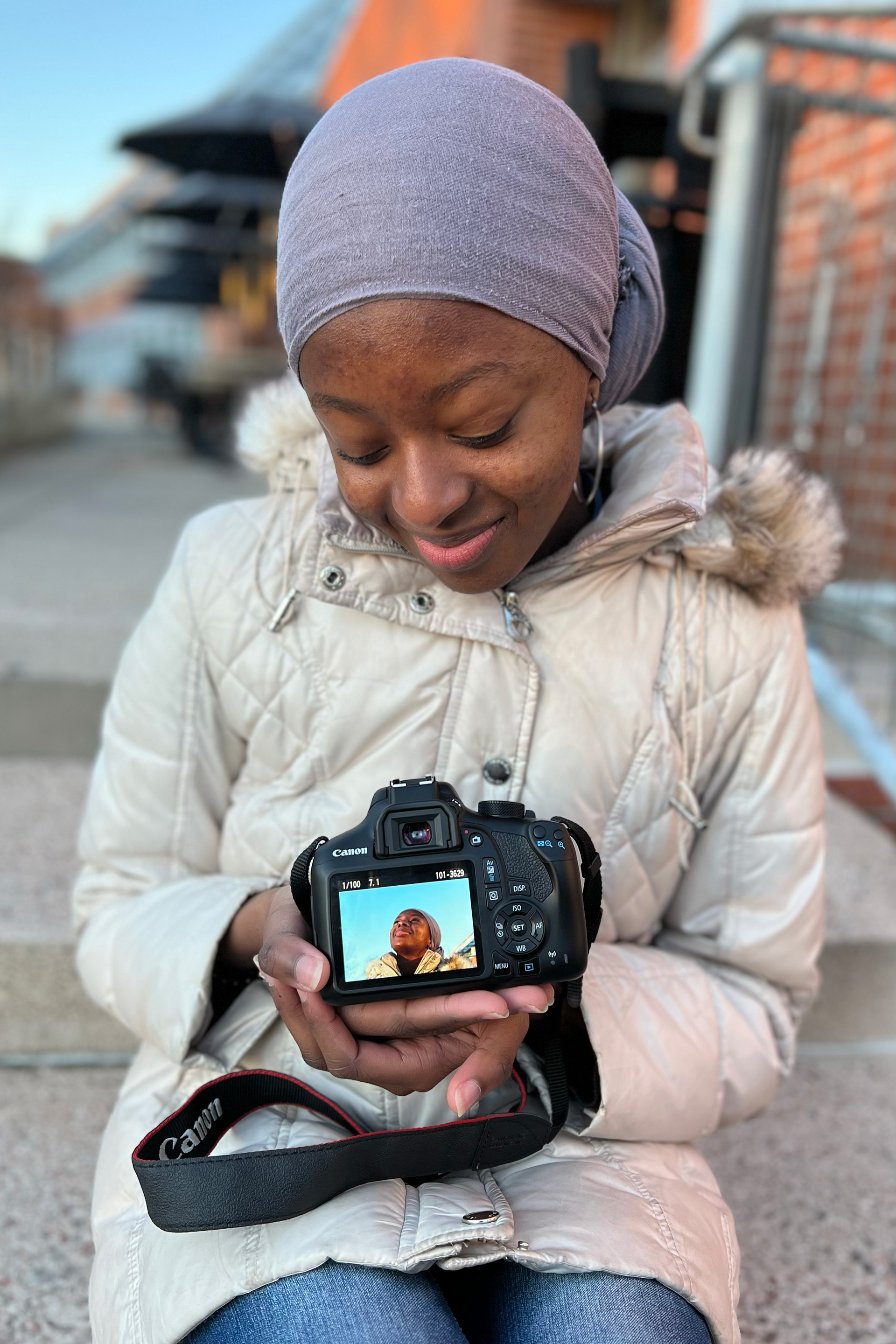 girl holding camera in hands, showing camera preview screen