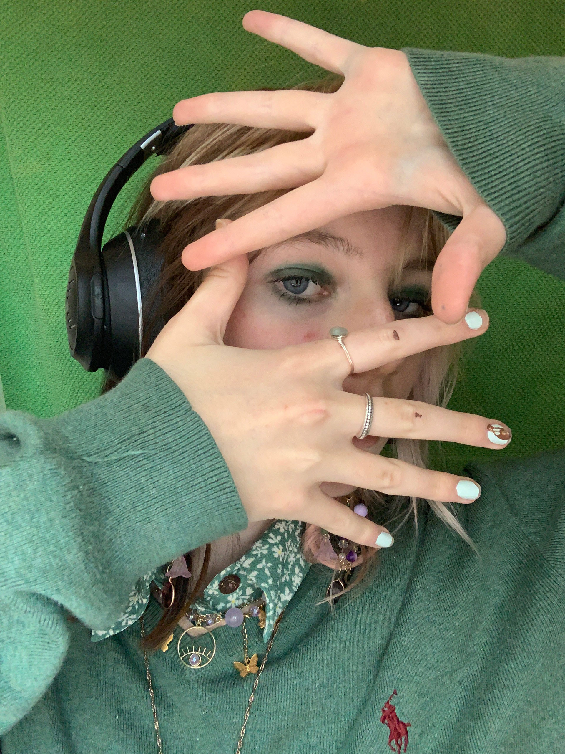 Portrait of a girl wearing headphones with hands in front of the face
