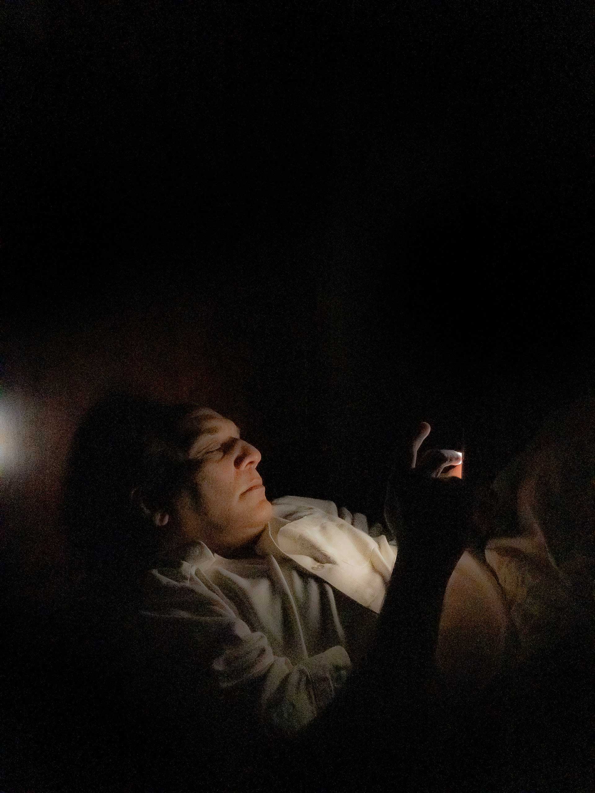 photo of a man laying down in a dark room