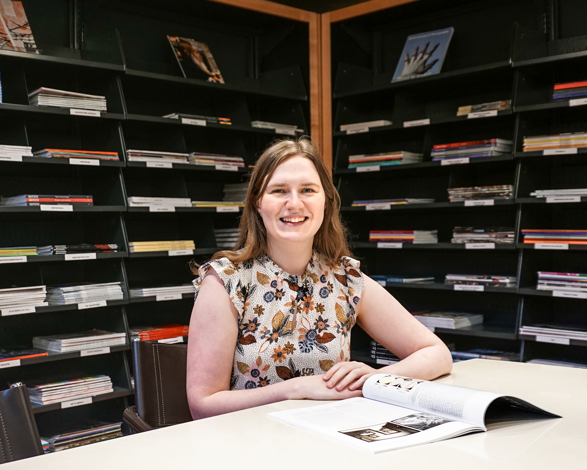 woman seated in front of periodicals