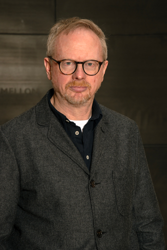 man wearing glasses and a gray blazer