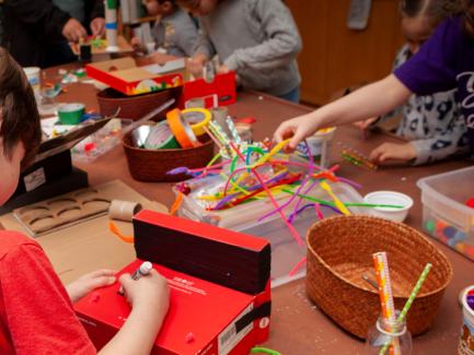 Children making crafts, using brightly colored pipe cleaners, pompoms, tape, markers, and other supplies at the Yale Center for British Art, photo by Harold Shapiro