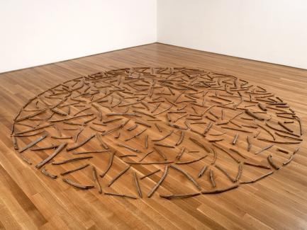 artwork consisting of branches arranged in a circle installed on the floor