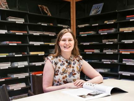 woman seated in front of periodicals